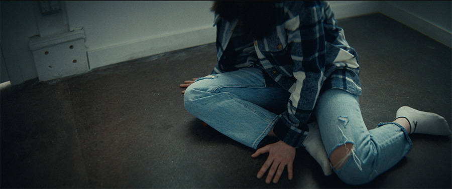 A woman in blue sitting on the floor