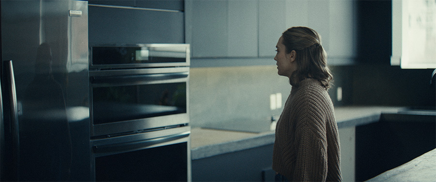 A woman looks at the oven